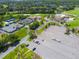 Aerial shot highlighting the community's tennis courts, clubhouse, golf course, and a parking area at 257 Sweet Bay Dr, New Smyrna Beach, FL 32168