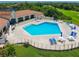 Sparkling pool with lounge chairs and umbrella tables surrounded by a manicured brick patio and green lawn at 257 Sweet Bay Dr, New Smyrna Beach, FL 32168