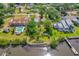 Aerial view showcasing a home's large lot with mature trees near the water and other homes at 2576 Sunset Dr, New Smyrna Beach, FL 32168