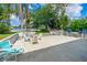 Large back patio with outdoor seating and mature tropical trees and bushes overlooking the water at 2576 Sunset Dr, New Smyrna Beach, FL 32168