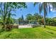 Backyard with a concrete patio area, perfect for outdoor dining and entertaining with lush greenery surrounding the property at 2576 Sunset Dr, New Smyrna Beach, FL 32168