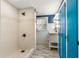Modern bathroom featuring a sleek white shower with tiled accents and bright blue cabinets at 2576 Sunset Dr, New Smyrna Beach, FL 32168