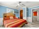Comfortable bedroom with a wood-frame bed, blue walls, and light-filled windows at 2576 Sunset Dr, New Smyrna Beach, FL 32168