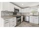 Modern kitchen featuring stainless steel appliances, stylish backsplash, and ample cabinet space at 2576 Sunset Dr, New Smyrna Beach, FL 32168