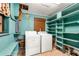 Functional laundry room with washer, dryer, and ample shelving for storage solutions at 2576 Sunset Dr, New Smyrna Beach, FL 32168