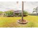 Sprawling backyard with a well-manicured lawn, landscaping, and screened-in pool area at 260 Portofino Blvd, New Smyrna Beach, FL 32168