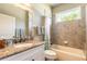 Bright bathroom with a tiled shower-tub combination and a vanity with granite countertop at 260 Portofino Blvd, New Smyrna Beach, FL 32168