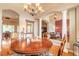 Elegant dining area featuring a chandelier, hardwood floors, and decorative columns flowing into the living room at 260 Portofino Blvd, New Smyrna Beach, FL 32168
