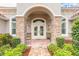 Inviting front entrance with stone pillars and colorful landscaping at 260 Portofino Blvd, New Smyrna Beach, FL 32168