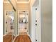 Hallway leading to the main bathroom featuring hardwood floors, and mirrored closet at 260 Portofino Blvd, New Smyrna Beach, FL 32168