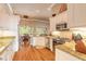 Well-lit kitchen with stainless steel appliances, light granite countertops, and hardwood floors and dining area at 260 Portofino Blvd, New Smyrna Beach, FL 32168