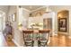 Bright kitchen with granite countertops, white cabinetry, stainless steel appliances, and barstool seating at the island at 260 Portofino Blvd, New Smyrna Beach, FL 32168