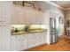 Kitchen featuring white cabinets, granite countertops, under-cabinet lighting, and stainless steel refrigerator at 260 Portofino Blvd, New Smyrna Beach, FL 32168