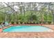 Inviting screened-in pool with brick-paved deck and well-maintained landscaping at 260 Portofino Blvd, New Smyrna Beach, FL 32168