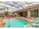 Enclosed pool with outdoor seating, lush greenery and a screened-in enclosure at 260 Portofino Blvd, New Smyrna Beach, FL 32168