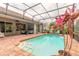 Enclosed pool area features brick-paved deck, lovely seating, and relaxing tropical backyard at 260 Portofino Blvd, New Smyrna Beach, FL 32168