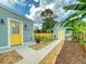 Charming backyard featuring a walkway between a house and shed, accentuated by banana trees and decorative rocks at 2714 Yule Tree Dr, Edgewater, FL 32141