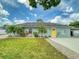 Charming single-story home features a well-manicured lawn and a bright yellow front door at 2714 Yule Tree Dr, Edgewater, FL 32141