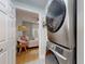 Convenient laundry area featuring a stacked washer and dryer set adjacent to a bedroom space at 2714 Yule Tree Dr, Edgewater, FL 32141
