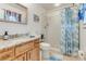 Tasteful bathroom with wood cabinets, granite countertop, and tiled shower at 2726 Victory Palm Dr, Edgewater, FL 32141