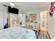 Bright bedroom featuring wood flooring, TV, ceiling fan, and decorative armoire and dresser at 2726 Victory Palm Dr, Edgewater, FL 32141