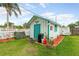 Charming outbuilding featuring a white exterior with green trim and a shingled roof at 2726 Victory Palm Dr, Edgewater, FL 32141