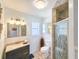 Well-lit bathroom featuring a vanity, toilet, shower, and decorative wall art at 2802 English Dr, Deltona, FL 32738