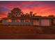 Charming single-story home with a colorful sunset, attached garage, and manicured lawn at 2802 English Dr, Deltona, FL 32738