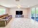 Spacious living room featuring tile floors, natural light, and a cozy leather sofa at 2802 English Dr, Deltona, FL 32738