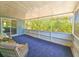 Enclosed sunroom featuring a blue carpet, wicker furniture, and access to the outdoors at 2802 English Dr, Deltona, FL 32738