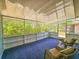 Relaxing sunroom with blue carpet, wicker furniture, and views of the outdoor greenery at 2802 English Dr, Deltona, FL 32738