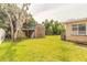 Expansive backyard with lush grass, mature trees, and a storage shed at 306 Jefferson Ave, Port Orange, FL 32127