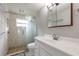 Classic bathroom with white vanity, glass shower, and light stone flooring at 306 Jefferson Ave, Port Orange, FL 32127