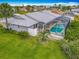 Aerial view of a home with a screened-in pool, lush landscaping, and a well-maintained yard nestled in a serene neighborhood at 31 E Sea Harbor, Ormond Beach, FL 32176