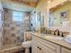 Modern bathroom showcasing a tiled shower with glass door and granite vanity at 31 E Sea Harbor, Ormond Beach, FL 32176