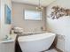 Modern bathroom featuring a stylish standalone tub, unique lighting fixture, and decorative wall art for a spa-like experience at 31 E Sea Harbor, Ormond Beach, FL 32176