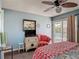 Bedroom featuring a bright chair, flatscreen TV, tropical bedding, and sliding door to patio at 31 E Sea Harbor, Ormond Beach, FL 32176