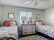 Bright bedroom featuring two twin beds with tropical bedding, and a ceiling fan at 31 E Sea Harbor, Ormond Beach, FL 32176
