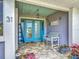 Cozy front porch with a blue door, seating, and beach-themed decor, creating a welcoming entrance at 31 E Sea Harbor, Ormond Beach, FL 32176