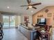 Comfortable living room with a leather sofa, ceiling fan, and sliding glass doors leading to the pool area at 31 E Sea Harbor, Ormond Beach, FL 32176