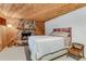 Basement bedroom features rustic wood paneled walls, a stone fireplace, and a bed at 315 Sweet Bay Ave, New Smyrna Beach, FL 32168
