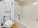 Bathroom features a marble tiled shower and tub combination, white toilet, and wood floors at 315 Sweet Bay Ave, New Smyrna Beach, FL 32168