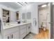 Clean and modern bathroom with double sinks, gray cabinetry, and a separate toilet room at 315 Sweet Bay Ave, New Smyrna Beach, FL 32168