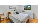 Charming bedroom with a patterned bedspread, wooden floors, and a blue dresser, illuminated by natural light at 315 Sweet Bay Ave, New Smyrna Beach, FL 32168