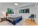 Cozy bedroom with large windows, hardwood floors, and a comfortable bed with stylish furnishings at 315 Sweet Bay Ave, New Smyrna Beach, FL 32168
