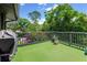 Cozy outdoor deck area featuring faux grass, potted plants, grill, and lovely views of the surrounding greenery at 315 Sweet Bay Ave, New Smyrna Beach, FL 32168
