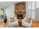 Cozy seating area with a stone fireplace, hardwood floors, and natural light at 315 Sweet Bay Ave, New Smyrna Beach, FL 32168