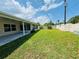 A lush backyard offers a view of the property's screened patio and lush lawn at 3303 Victory Palm Dr, Edgewater, FL 32141