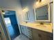 Bathroom featuring a double vanity with white countertops, gray cabinets, and blue walls at 3303 Victory Palm Dr, Edgewater, FL 32141