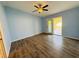 Spacious bedroom with light blue walls, wood flooring, ceiling fan, and sliding glass doors at 3303 Victory Palm Dr, Edgewater, FL 32141